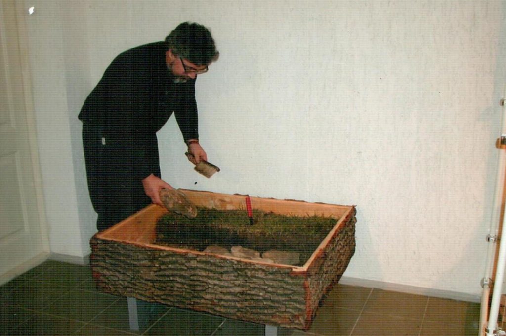 Михайло Відейко працює над реконструкцією залишків житла трипільської культури у третьому залі, 2002 рік